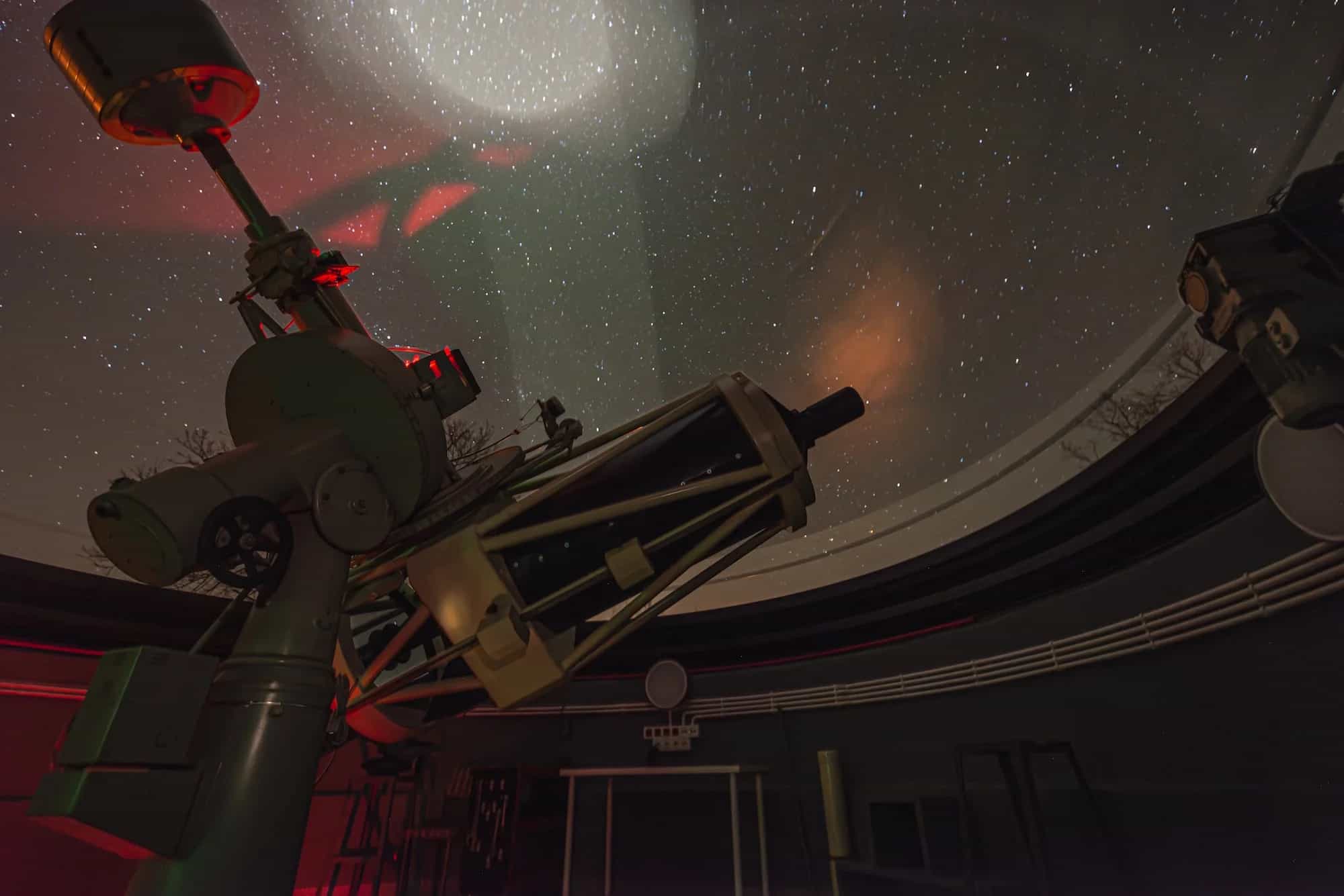 BLT telescope inside an observatory with a fully opened dome, pointed toward a star-filled night sky.